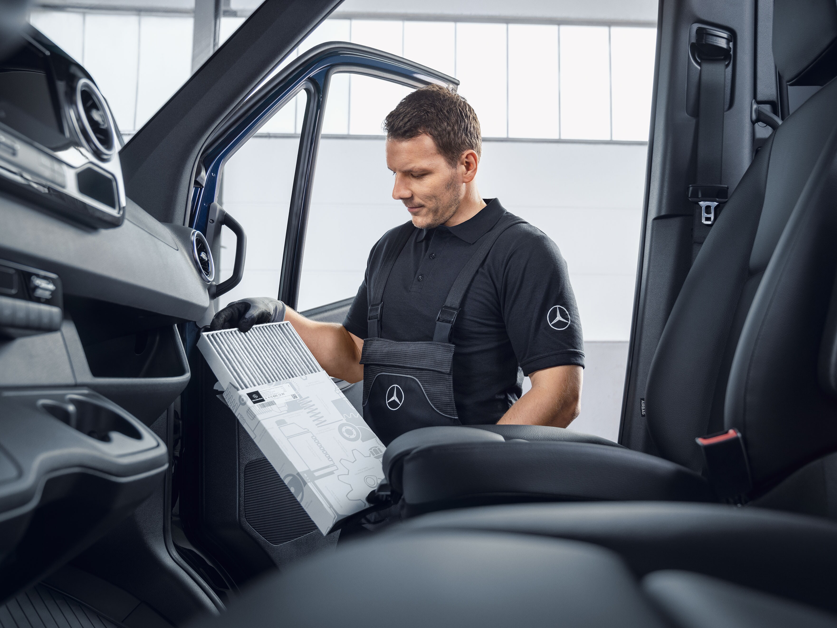 En Mercedes-Benz mekaniker skifter luftfiltre.