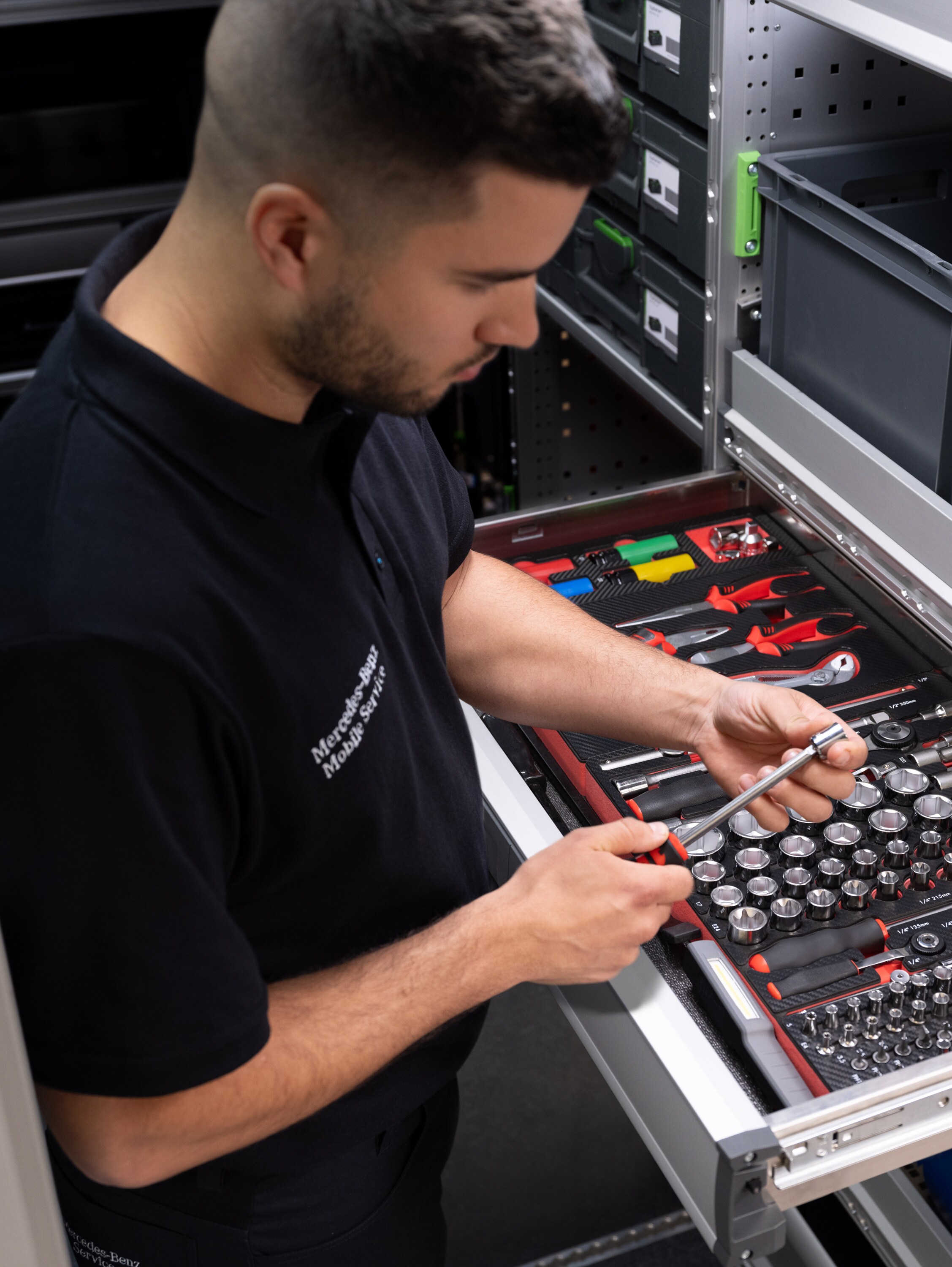 En Mercedes-Benz tekniker vælger et værktøj fra en værktøjsskuffe.