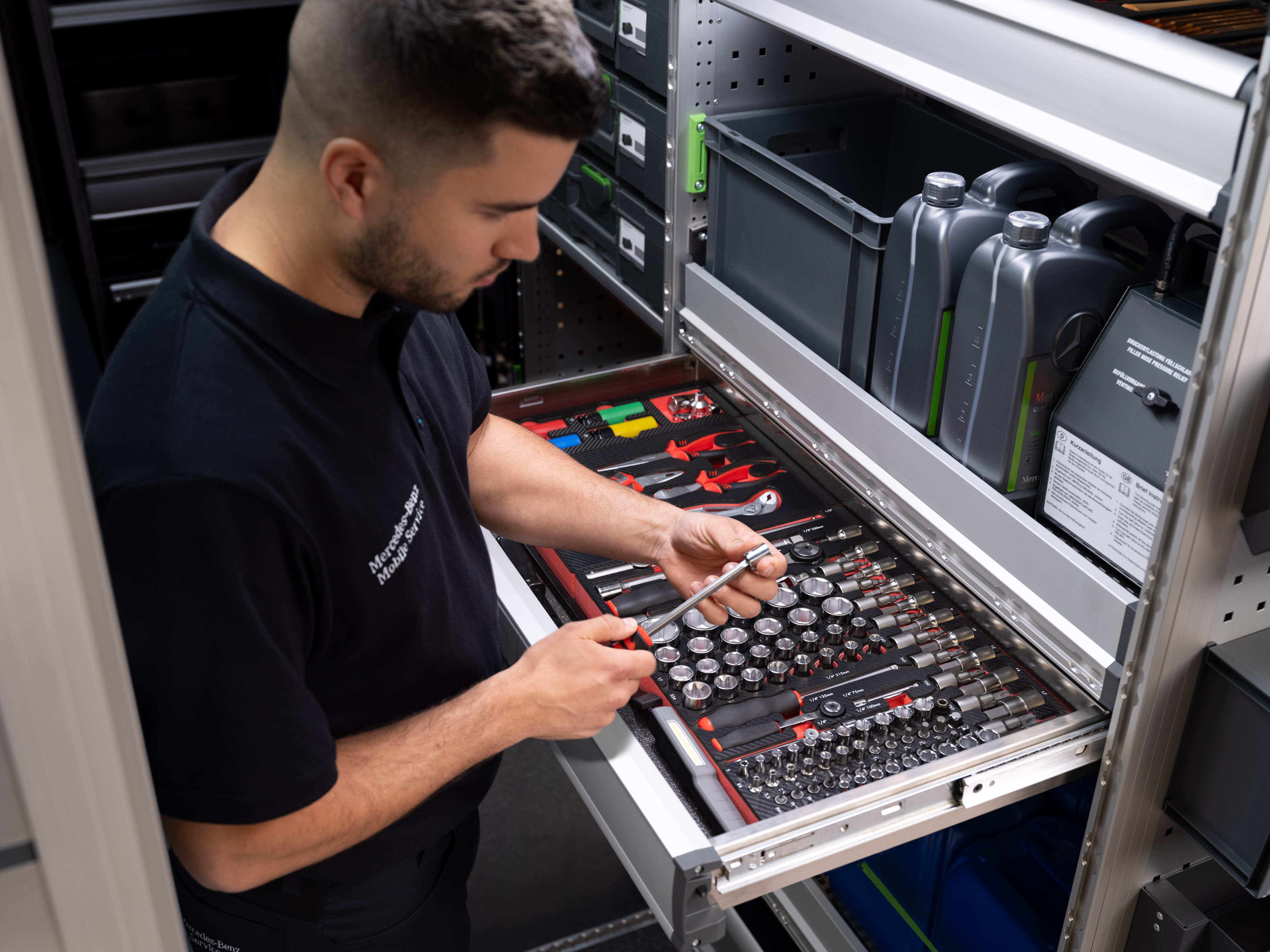 Mercedes-Benz | Mobile Service til varebiler | Elektronik og software En Mercedes-Benz tekniker vælger et værktøj fra en værktøjsskuffe.