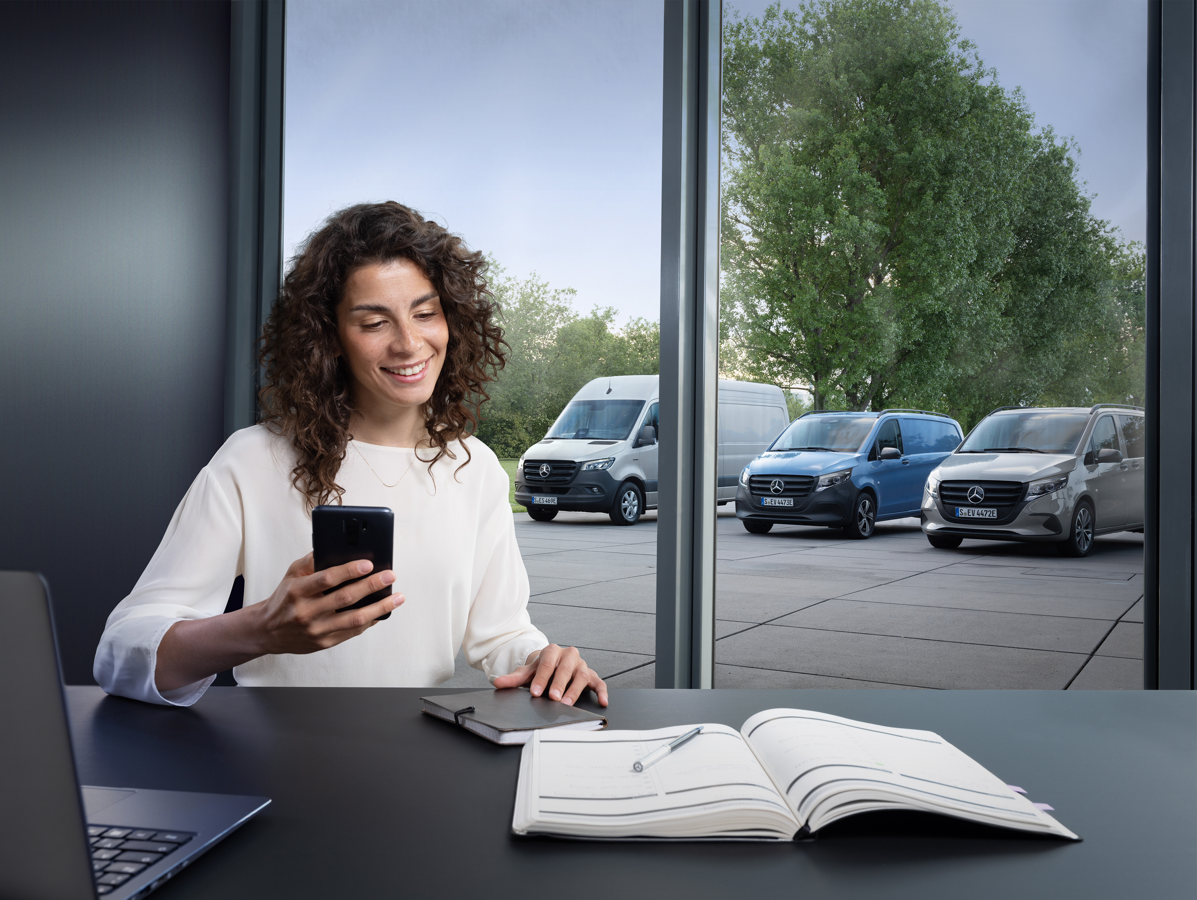 ServiceCare til varebiler | Mercedes-Benz varebiler Kvinde booker tid hos lokal Mercedes-Benz servicepartner via smartphone.