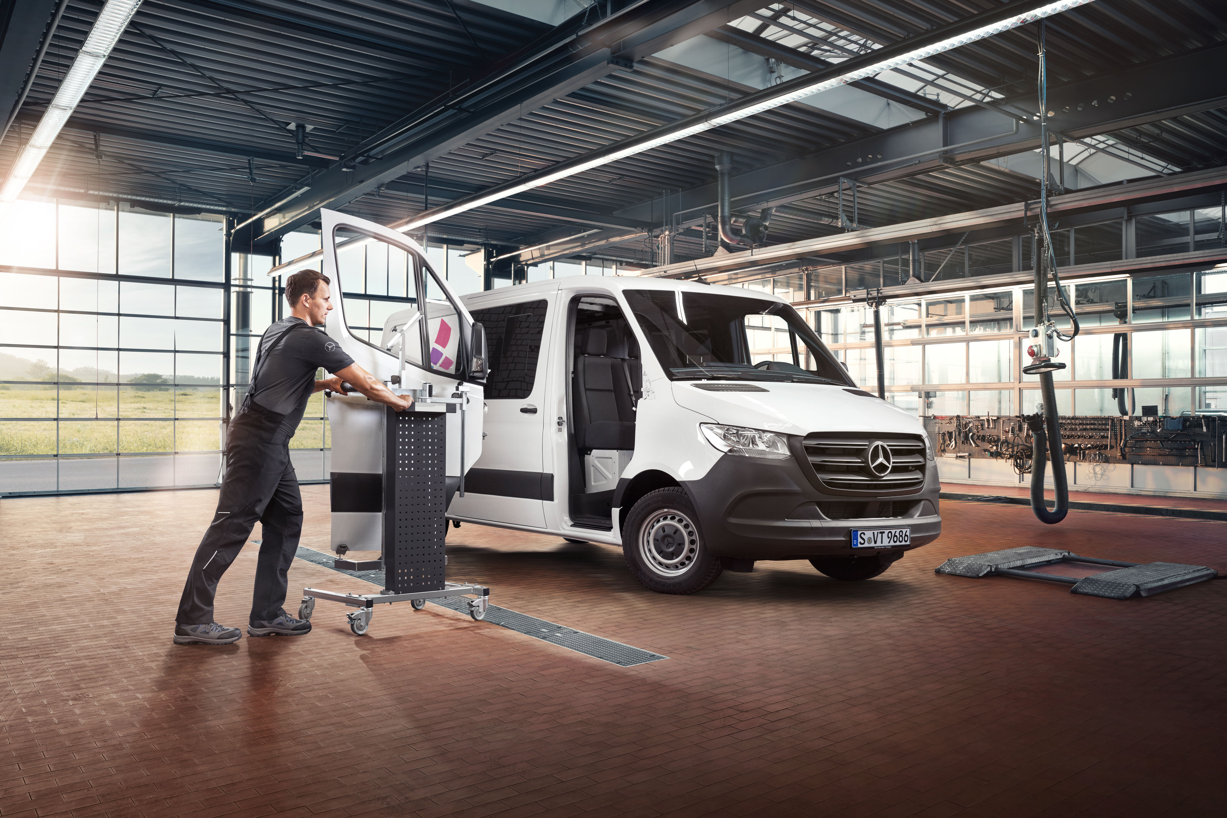 Mercedes-Benz | Reparation Mekaniker monterer døren på en hvid Mercedes-benz Sprinter.