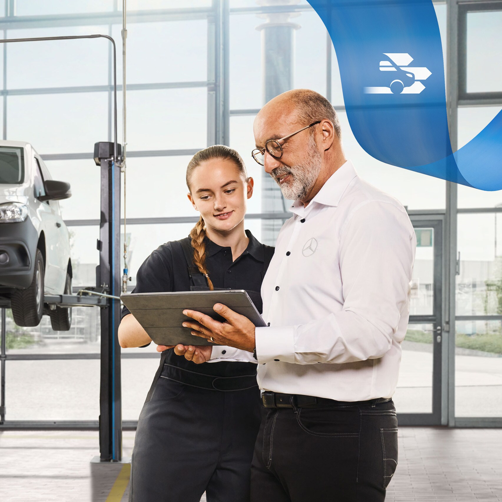 To medarbejdere taler om service på en opklodset Mercedes-Benz varebil på værkstedet.