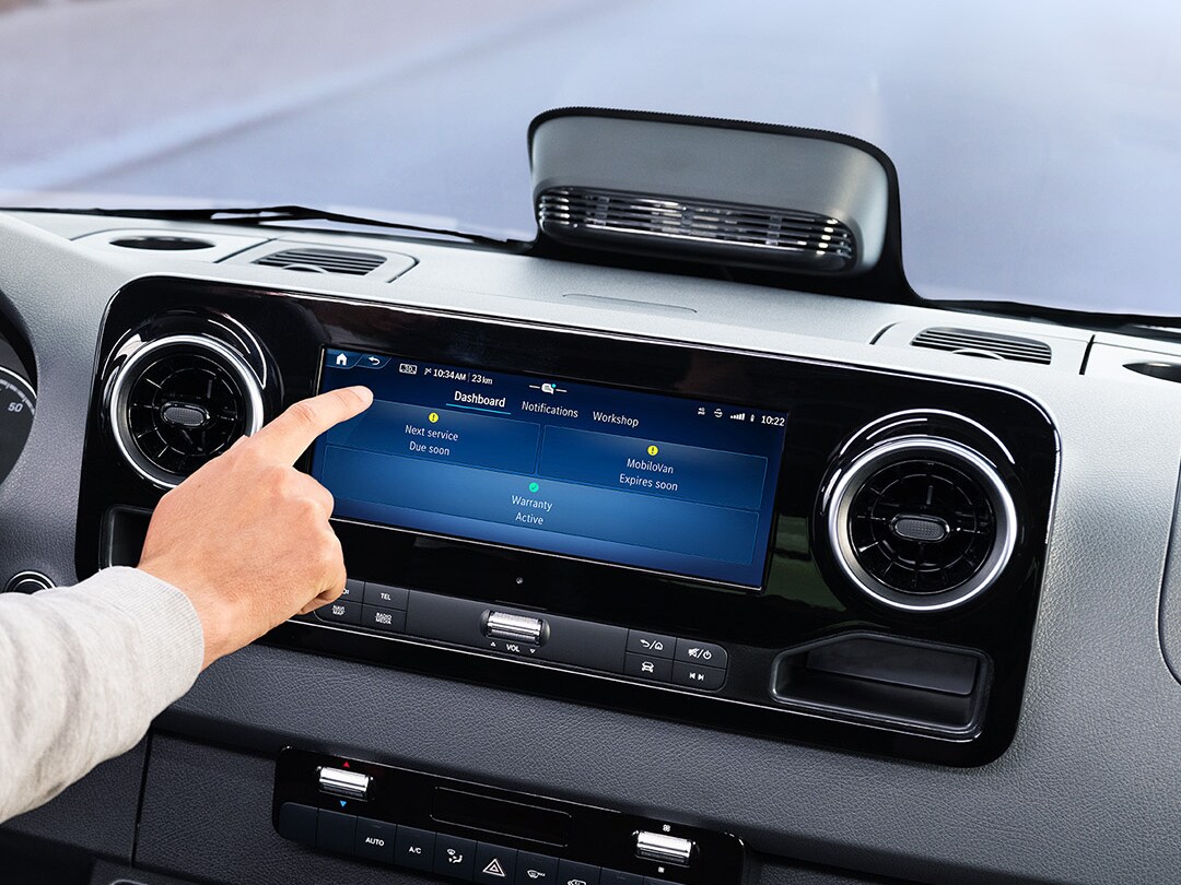 En chauffør bruger service-appen på bilens display til at tjekke bildata og servicemuligheder.