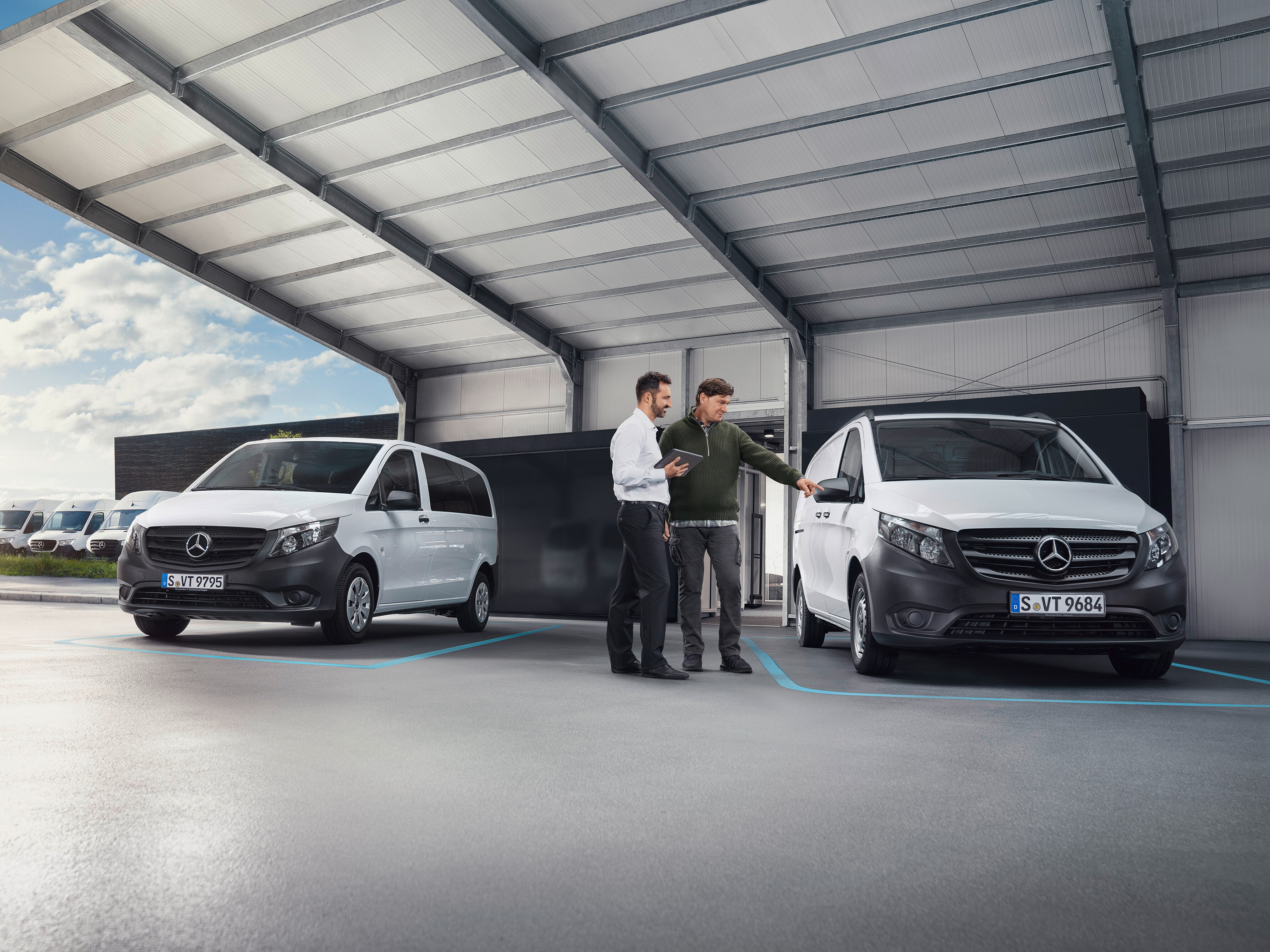 Mercedes-Benz forhandler og kunde kigger på forskellige varebiler