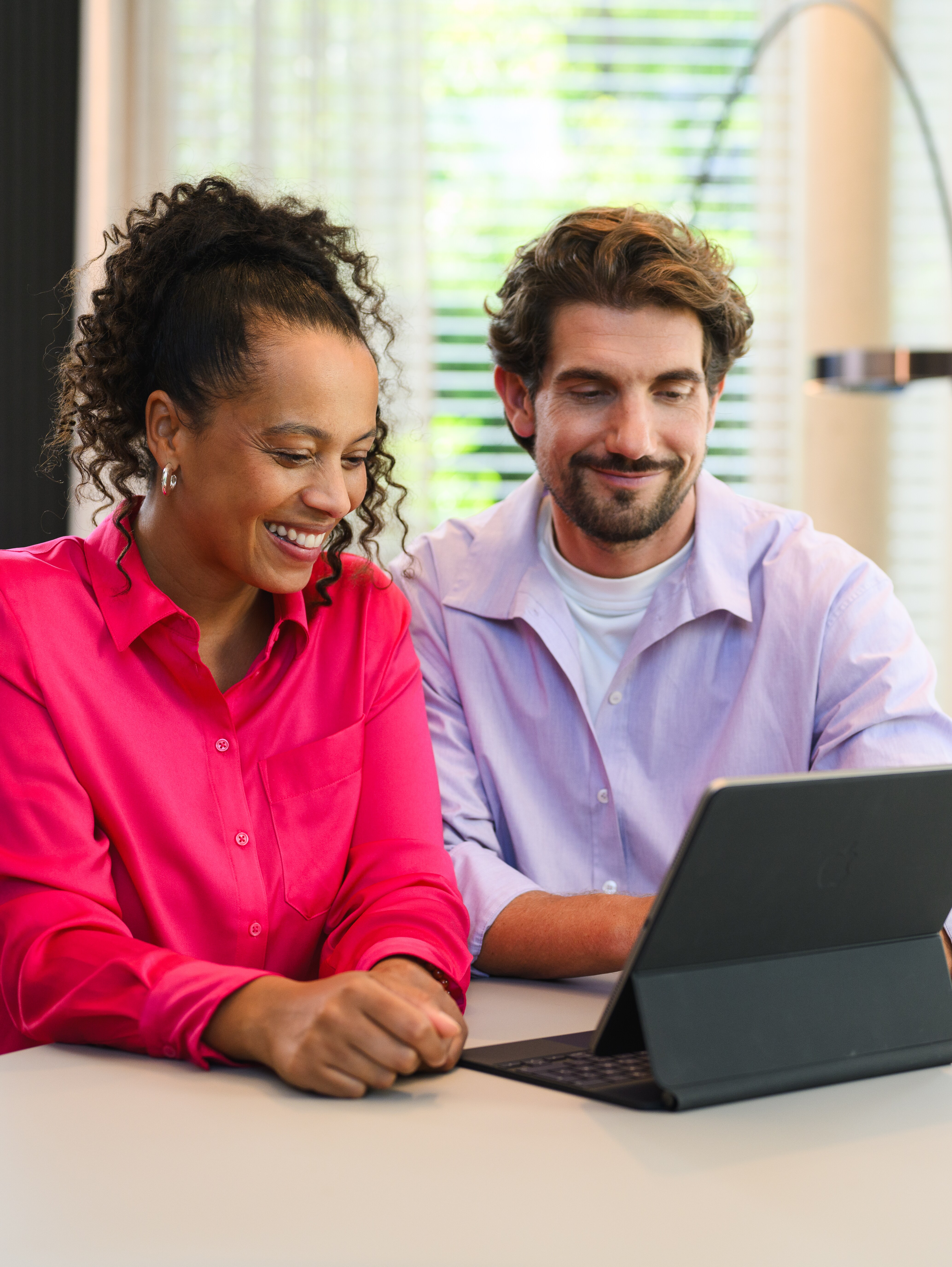 Mand og kvinde sidder med en tablet og køber en Mercedes-Benz online