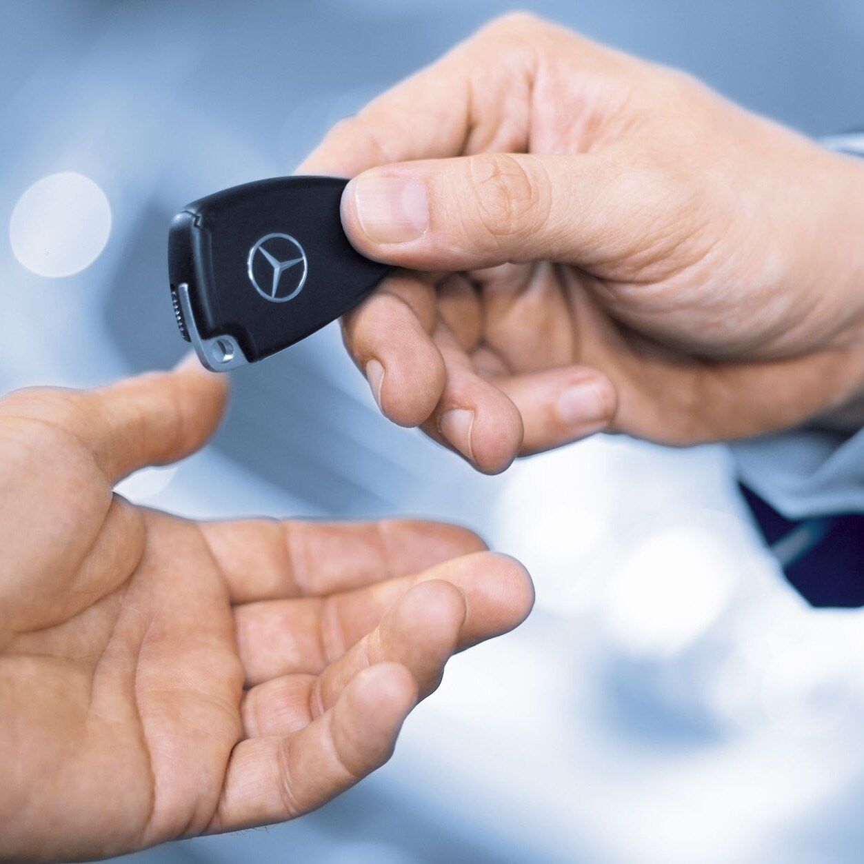 Mercedes-Benz ansat afleverer bilnøgle til kunde