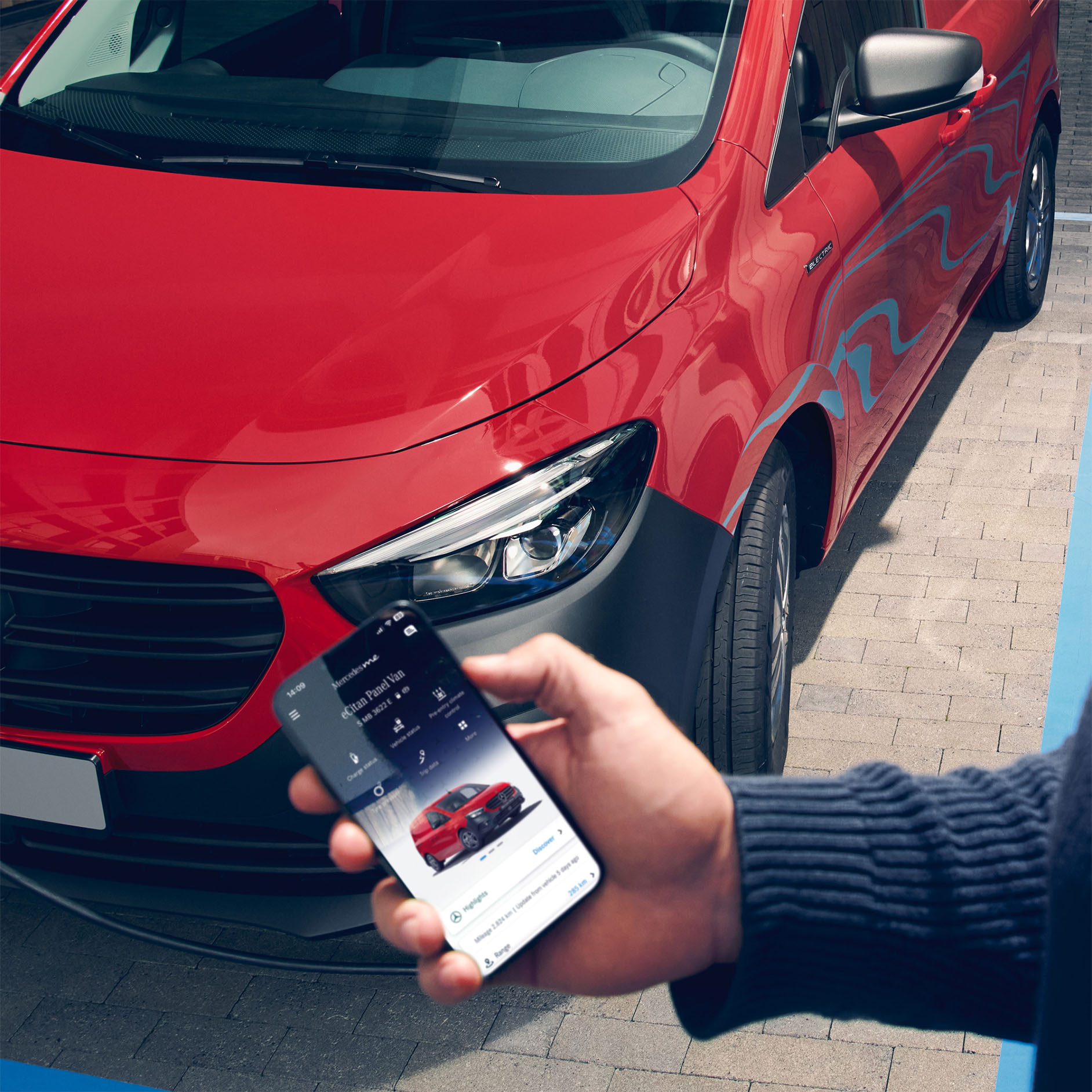 Invester i fremtiden | Elbiler og økonomi | Mercedes-Benz Vans Person med mobiltelefon foran rød eCitan Kassevogn
